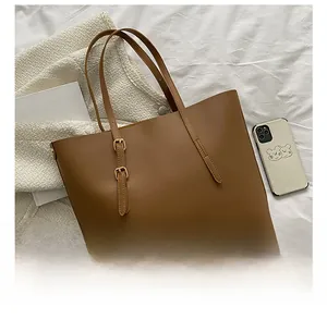 Overhead shot of a brown leather tote bag with gold buckles and large capacity storage