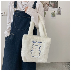 Gros plan du sac fourre-tout en peluche blanche avec broderie ours bleue et Beat Beat