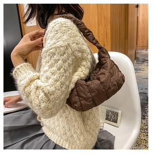 Close-up of brown quilted pleated hobo bag with a soft texture for autumn winter fashion