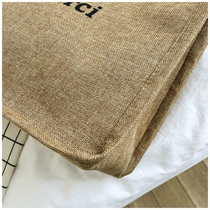 Detail of reinforced bottom stitching and natural jute texture on large canvas tote bag