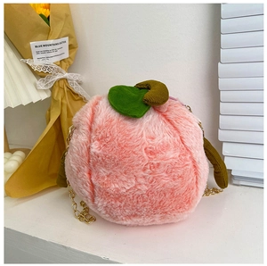Detail of peach-shaped plush bag with pink faux fur, green leaves and gold metal chain
