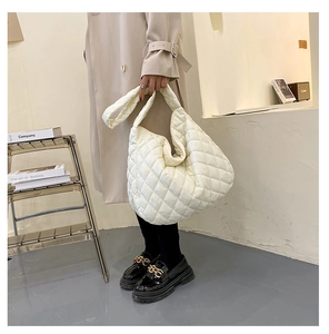 Detail of large quilted puffer shoulder bag in beige with soft diamond stitching