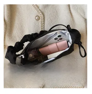 Detail presentation showing black pleated cloud bag interior with phone and wallet