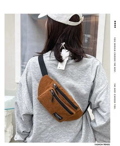 Detailed view of a brown corduroy chest bag with adjustable strap and fashion label