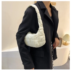 Chic white quilted cloud dumpling bag styled on a model wearing a black blazer jacket