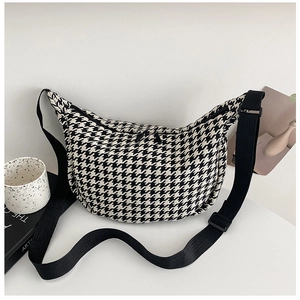 Close-up of black and white houndstooth pattern fabric on crescent crossbody bag