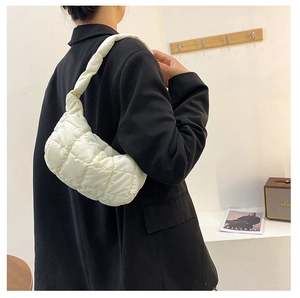 Detailed close-up of the white quilted nylon fabric texture on a large hobo shoulder bag