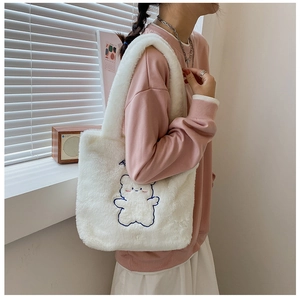 Détail de la broderie ours bleu sur un sac cabas en peluche blanche douce