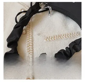 Detail of black pleated shoulder strap with high-quality fabric and silver metal zipper