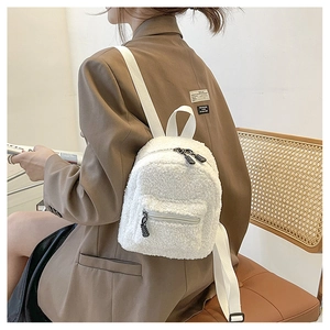 Detail of white faux shearling mini backpack with soft plush texture and woven straps
