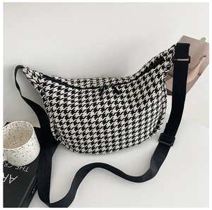 Detail shot of the houndstooth crossbody bag with adjustable black shoulder strap