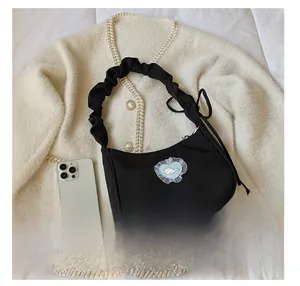 Detail of black canvas bag with blue heart whale embroidery and ruffled cloud handle