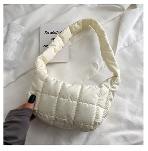 Detailed view of cream quilted puffer shoulder bag with a soft crescent shape design