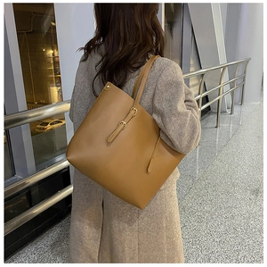 Detail of matte brown leather tote bag with elegant strap buckle and fine texture