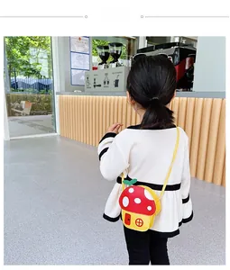 Vue arrière d'un enfant portant un sac à bandoulière coloré en forme de maison champignon