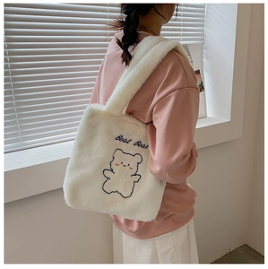 Détail du sac fourre-tout en peluche blanche avec broderie d'ours bleu et bandoulière