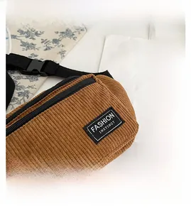 Detailed macro view of brown corduroy waist bag with FASHION INSTINCT woven label