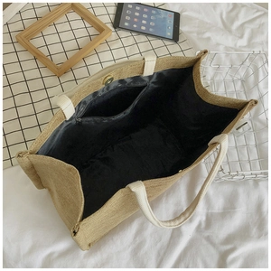 Detailed interior of jute tote bag showing black lining, zipper pocket, and magnetic snap
