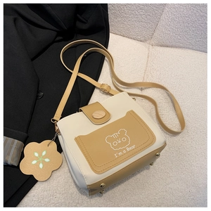 Detail view of contrast color bucket bag with cartoon bear and adjustable strap