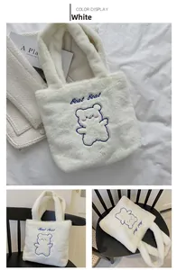 Détail du cabas en peluche montrant la fausse fourrure blanc chaud et la broderie bleue