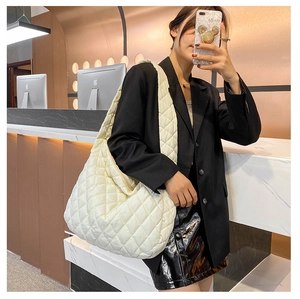 Detailed view of large white quilted cloud bag with padded texture for daily commute