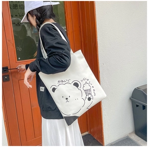 Canvas tote bag with cute bear and ice cream print shown on a model's shoulder