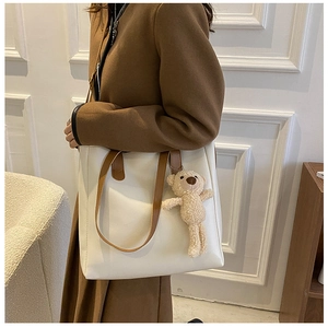 White faux leather tote bag with brown straps and cute teddy bear charm detail