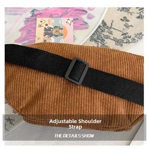 Detail of adjustable black strap on a brown corduroy crossbody bag with plastic buckle