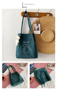 Dettaglio della borsa tote in velluto a coste verde con ricamo a orsetto e peluche