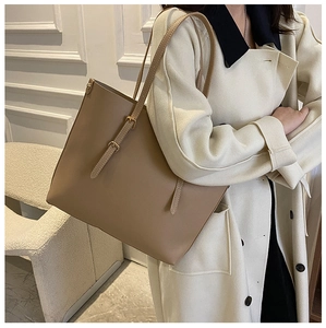 Khaki faux leather tote bag close-up showing adjustable strap metal buckles and texture