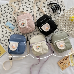 Flat lay of small canvas crossbody bags in five colors with cute bear motifs