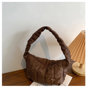 Detail of brown quilted nylon hobo bag featuring large square stitching and soft texture