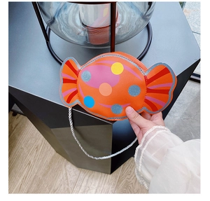 Vue latérale du sac à bandoulière orange en forme de bonbon avec pois colorés et corde argentée