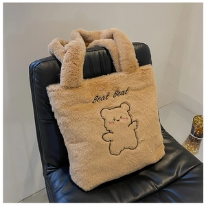 Détail d'un sac cabas en peluche avec broderie ours mignonne et texture en fausse fourrure brune