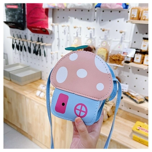 Détail d'un sac bandoulière champignon pour enfant avec toit rose à pois et base bleue