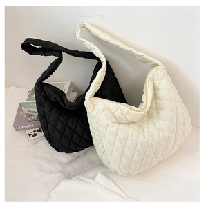 Detail view of large quilted hobo bags in black and cream on white background
