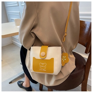 Detail of crossbody bucket bag featuring contrast colors and a cute bear graphic print