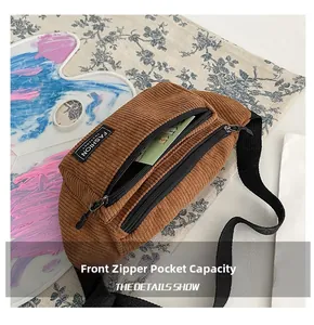 Detailed view of the front zipper pocket on a brown corduroy chest bag with brand label