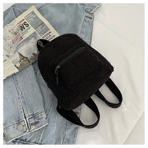 Detailed view of black faux shearling mini backpack with pockets on lifestyle background