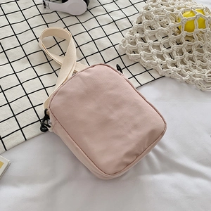 Cute pink canvas crossbody bag for women with adjustable strap in a fresh aesthetic setting