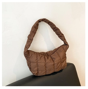 Detail of dark brown quilted puffer shoulder bag with elegant rhombic stitching design