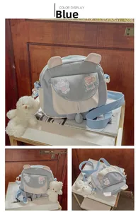 Close-up of blue bunny ear crossbody bag with cute bear plush charm and embroidery details