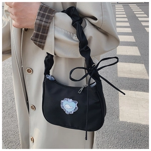 Detail der schwarzen Plissee-Tasche mit blauem Herz-Spitzen-Patch und Wal-Motiv