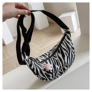 Detail of nylon hobo bag with zebra print pattern and a cute cow-shaped pendant charm