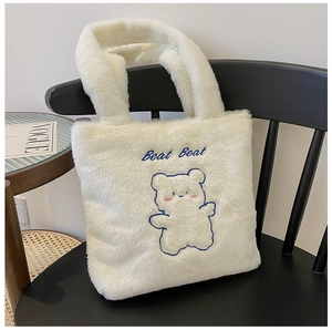 Détail du sac cabas en peluche blanche avec broderie ours bleu et texte Beat Beat