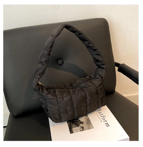 Detailed view of the black quilted shoulder bag featuring glossy nylon fabric and soft texture