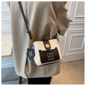 Detail of crossbody bucket bag with contrast brown flap and cute cartoon bear print