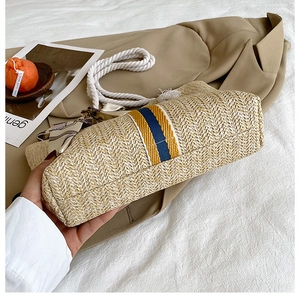 Detailed macro view of woven straw bag bottom with blue and yellow stripe accents