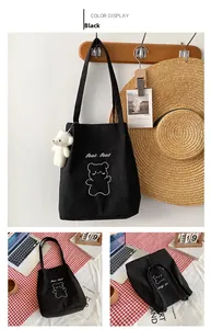 Dettaglio borsa shopper in velluto a coste nero con ricamo orso e ciondolo di peluche