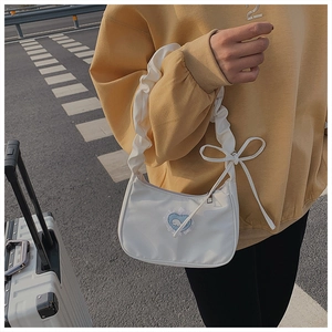 Detail der weißen Nylon-Schultertasche mit blauem Herz-Wal-Patch und gerafftem Griff